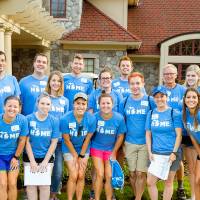 Alumni pose in front of the Alumni House